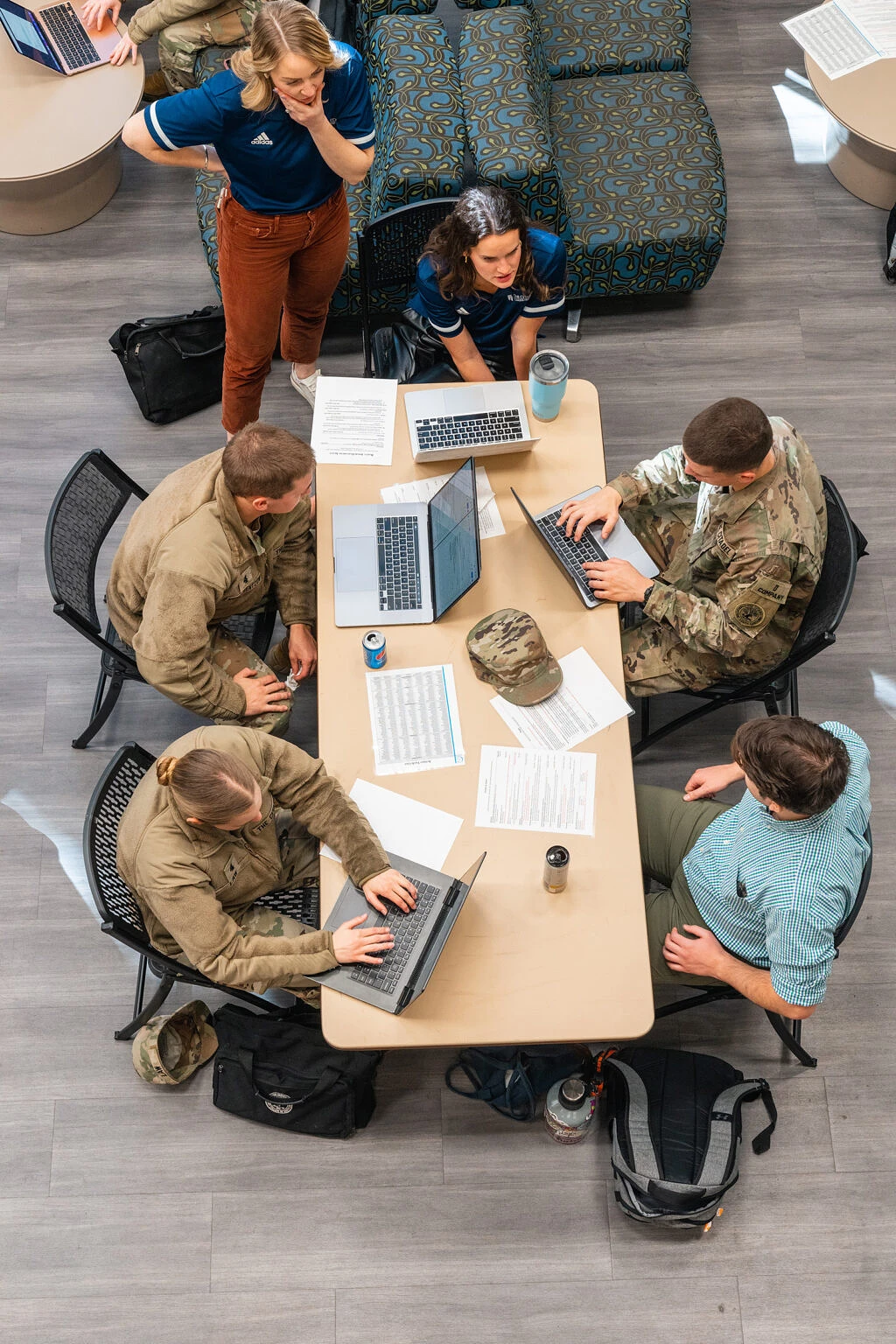 A group of colleagues is having a discussion during a meeting, with one person presenting information on a tablet.
